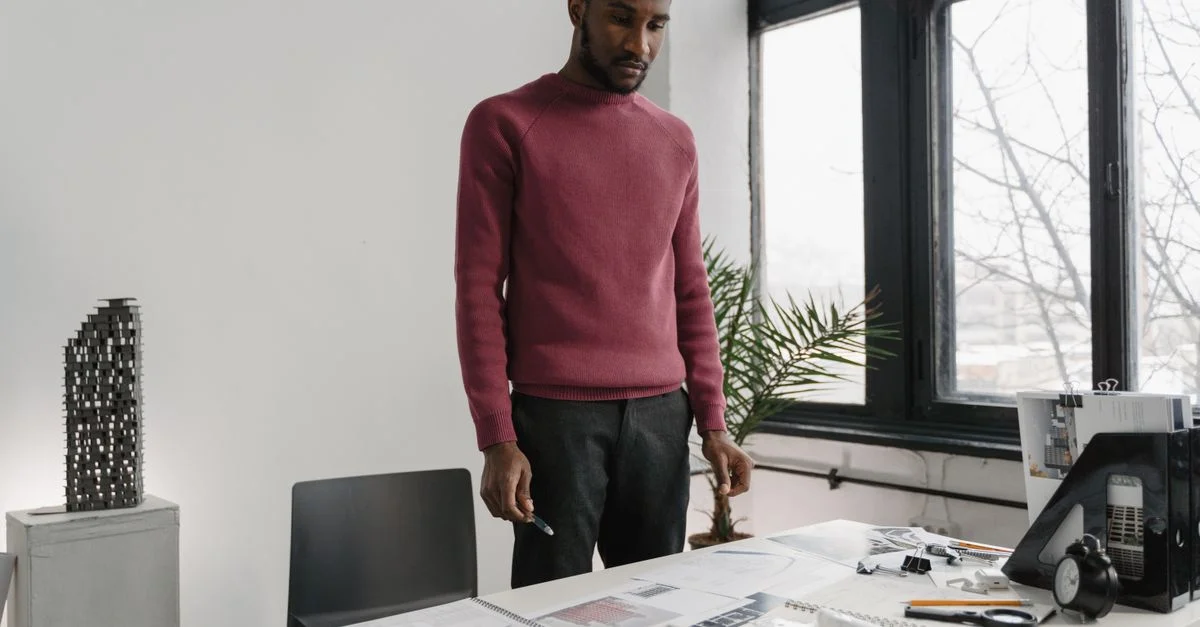 Architecte professionnel examinant des plans dans un espace de travail moderne et élégant.