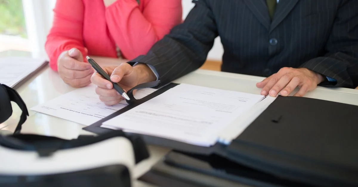 Gros plan de professionnels signant un contrat commercial à l'intérieur, mettant l'accent sur l'accord et la documentation.