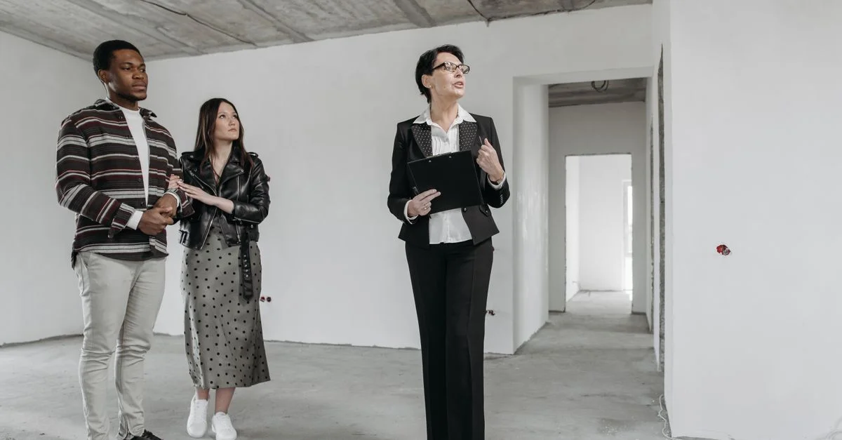 Un agent immobilier montre un appartement inachevé à des acheteurs potentiels.