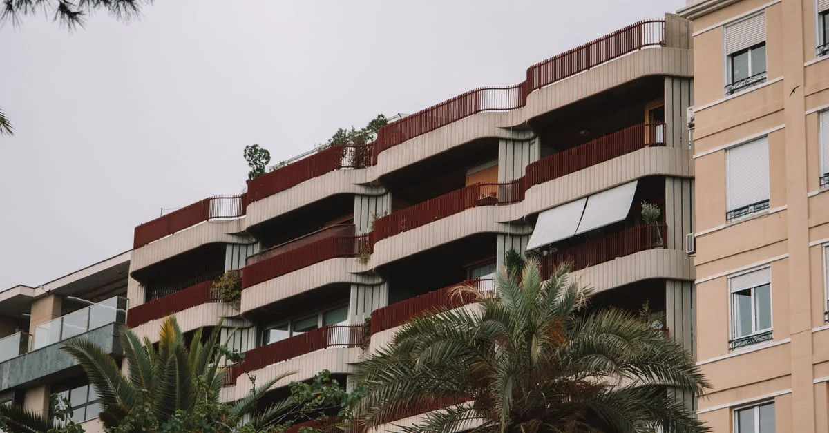 Une vue détaillée de l'architecture moderne d'appartements à Valence, Espagne, avec des palmiers encadrant la scène.
