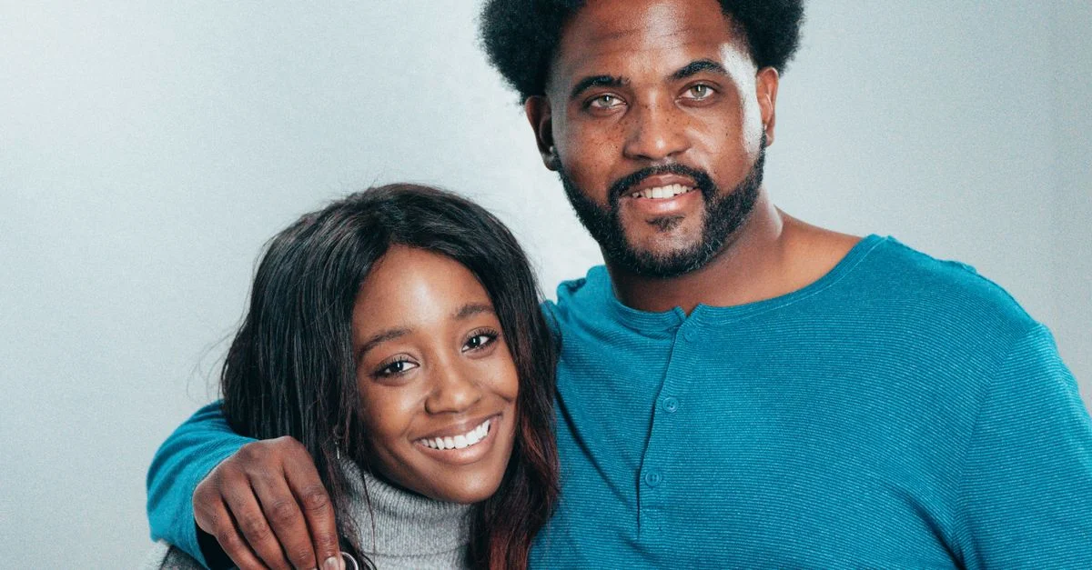 Un couple afro-américain souriant tenant des clés, célébrant leur accession à la propriété.