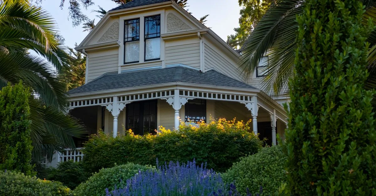 Une belle maison de style victorien entourée d'un jardin vibrant et luxuriant.
