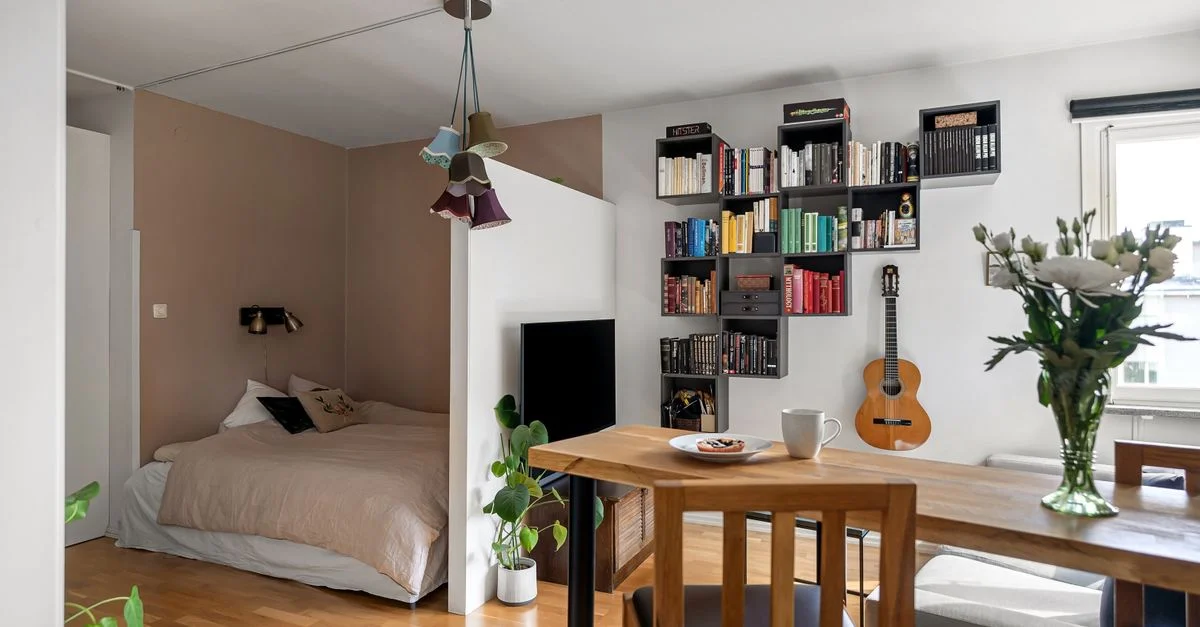 Un appartement studio élégant avec un lit douillet, une bibliothèque et un décor moderne.