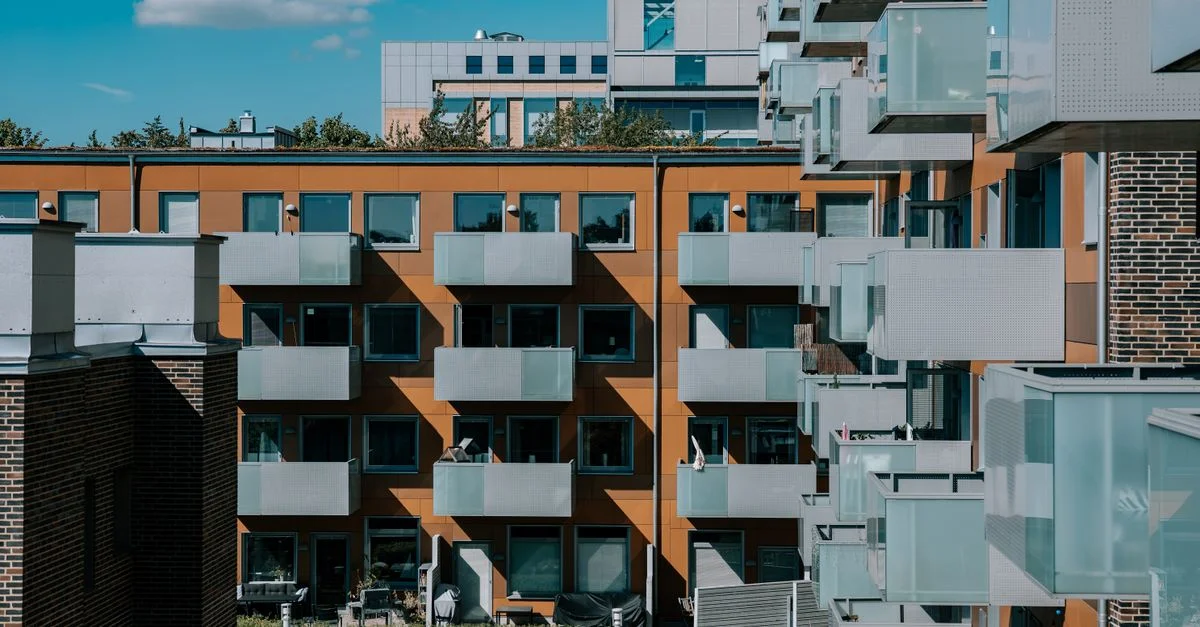 Architecture d'appartement contemporaine avec balcons sous un ciel ensoleillé à Lund, en Suède.